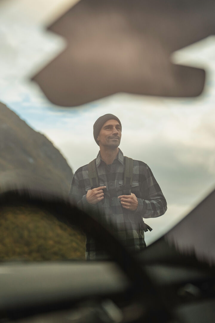 man hiking, picture through car window